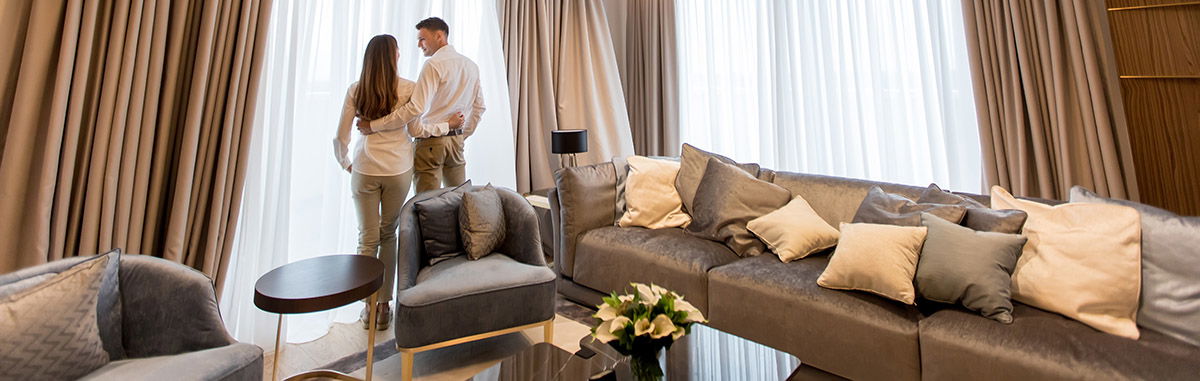 Couple embracing standing in living room of a contemporary apart